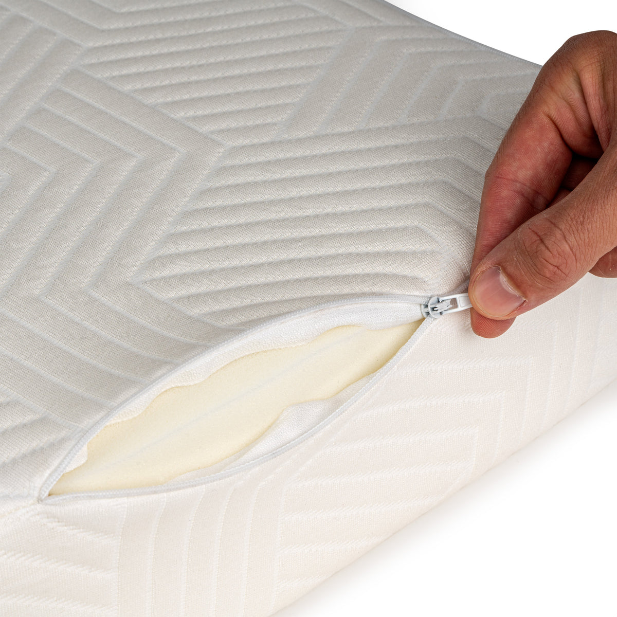 Hand opent de rits van de SidePillow tijk met zichtbare kern