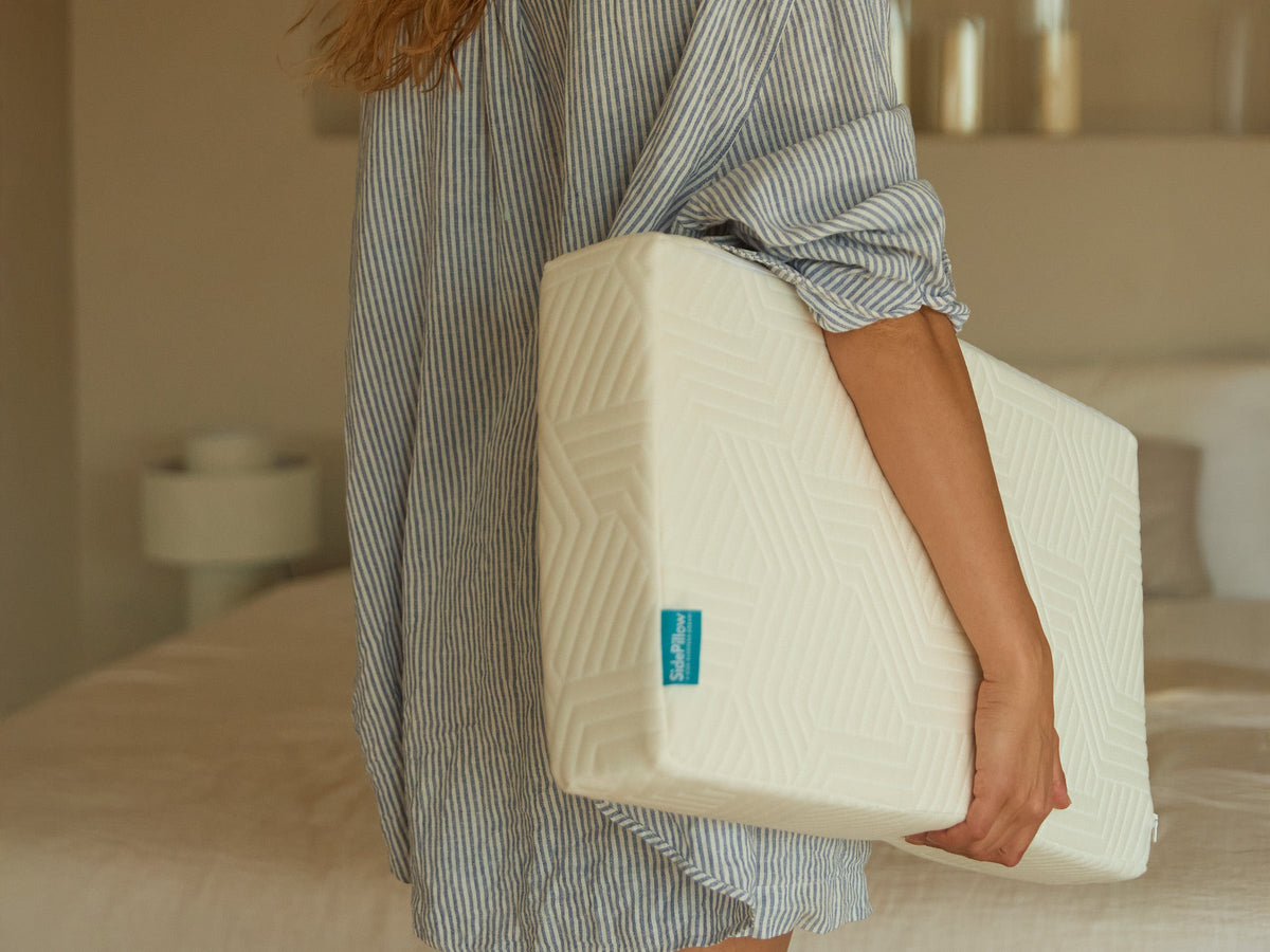 Hand houdt een nieuw SidePillow kussen vast